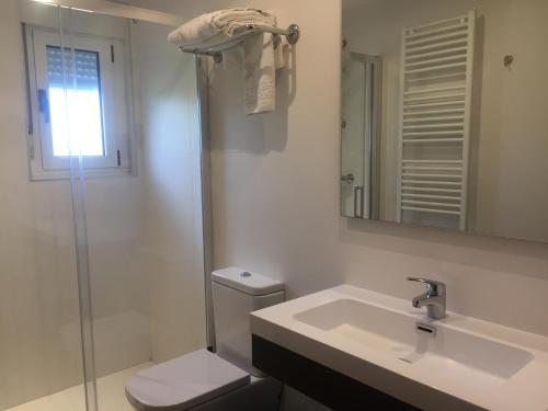 a bathroom with a sink and a toilet and a mirror at Hotel Rural Valle San Emiliano in San Emiliano