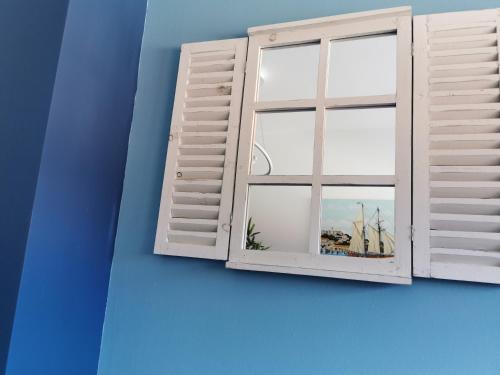 a window in a blue room with a view of the sails at Romana Dream apartment in Vrsar