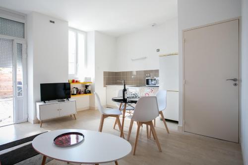 a white living room with a table and chairs at Appartement avec Terrasse in Périgueux