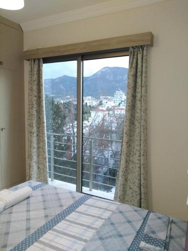 a bedroom with a bed and a large window at Aqua Royal Alexus Luxury Holiday Apartments Girne in Kérynia
