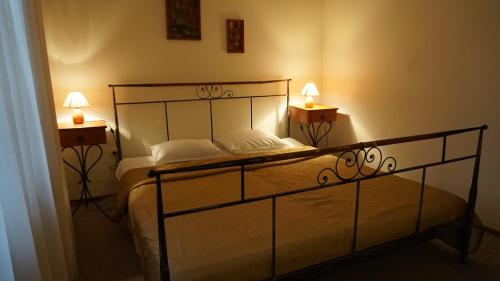 a bedroom with a bed with two lamps on it at Хотел-Ресторант Тиролиа in Gorna Oryakhovitsa