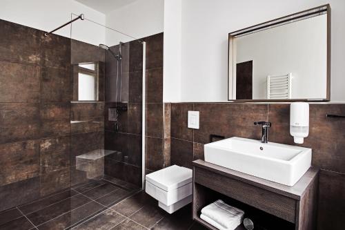bagno con lavandino, servizi igienici e specchio di GRONERS Leipzig a Lipsia