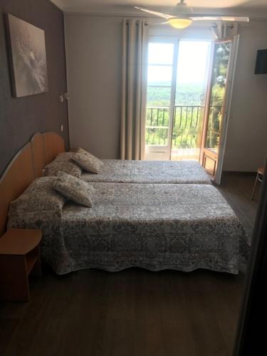 a bedroom with a bed and a large window at Les Belles Terrasses in Tourrettes-sur-Loup