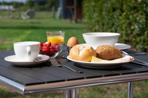 a table topped with plates of food and cups of coffee at Antonius Hoeve in Oudenbosch