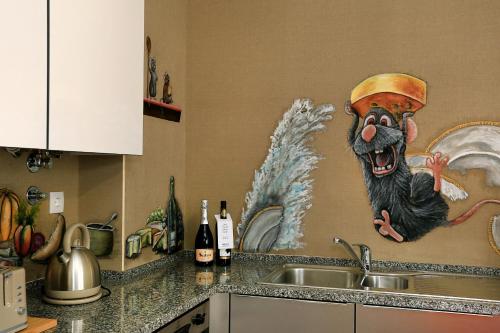 a kitchen with a mural of a monkey on the wall at HENRI'S APARTMENTS - Pátio do Convento in Lagos