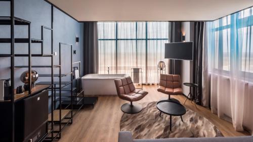 a room with a desk and two chairs and a table at Palace Hotel Zandvoort in Zandvoort