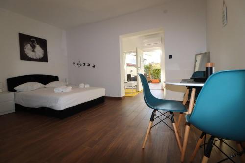 Schlafzimmer mit einem Bett, einem Schreibtisch und einem Stuhl in der Unterkunft Apartments Sain with garden terrace near the beach in Poreč
