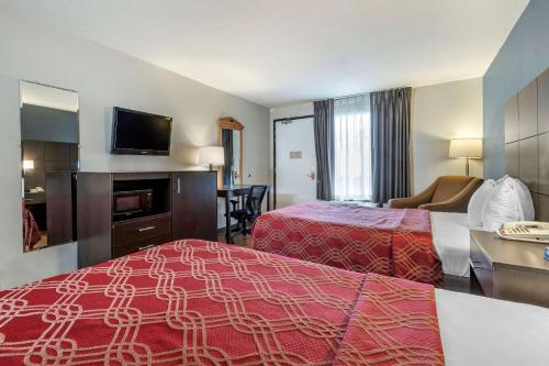 a hotel room with two beds and a flat screen tv at Econo Lodge North in Charleston