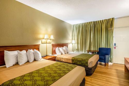 Pokój hotelowy z 2 łóżkami i krzesłem w obiekcie Econo Lodge Lake City-North w mieście Lake City