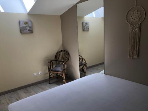 a bedroom with two chairs and a bed and a window at appart Pacificae in Remoulins