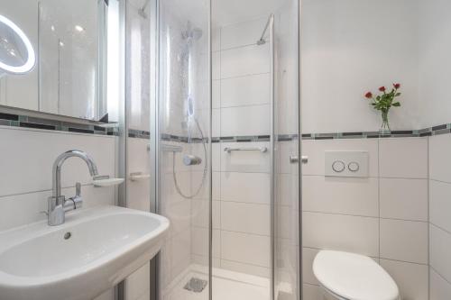 a white bathroom with a sink and a shower at Oberstdorfer Bergwelt 108 in Oberstdorf