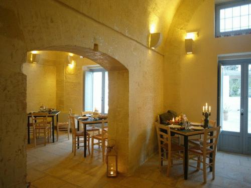 a dining room with tables and chairs in a building at Masseria Montelauro in Otranto