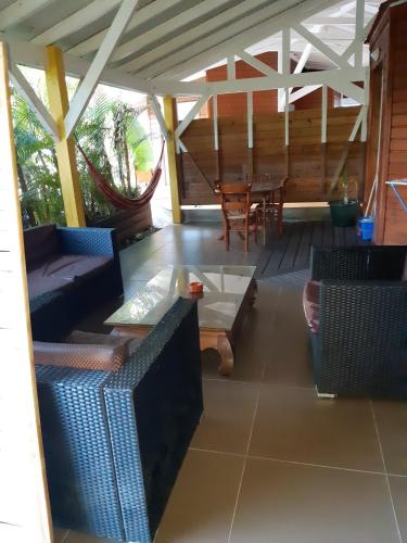 a screened in porch with a table and chairs at Bungalow de 2 chambres avec piscine partagee jacuzzi et terrasse amenagee a Le Gosier a 5 km de la plage in Le Gosier