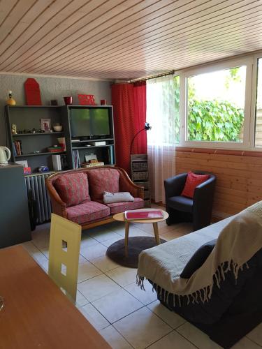 a living room with a couch and a tv at Gîte Mercues in Mercuès