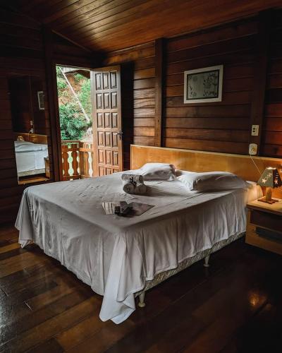 a bedroom with a bed in a room with wooden walls at Pousada Aracê in Pedra Azul