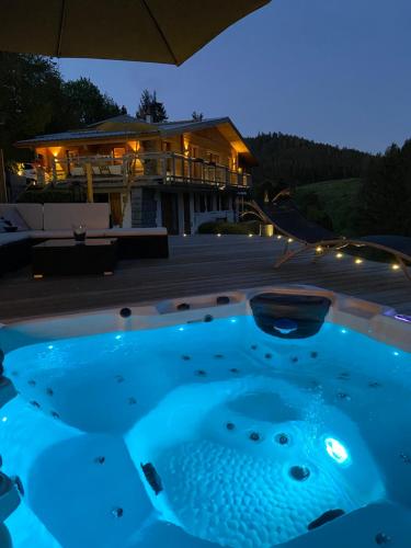 a hot tub in front of a house at night at Appartement de montagne au Chalet de Snow in Xonrupt-Longemer