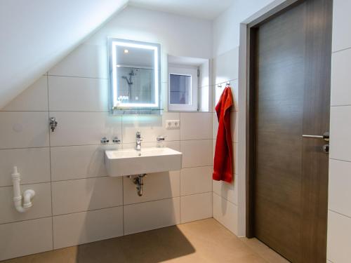 uma casa de banho com um lavatório e um espelho em Restaurant & Appartements In Vino Veritas em Haslach im Kinzigtal
