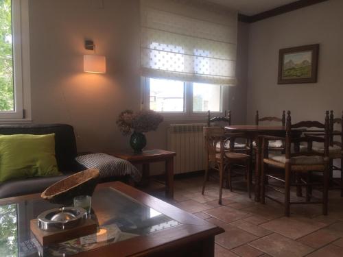 a living room with a table and a dining room at Hotel Rural Valle San Emiliano in San Emiliano