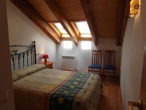 1 dormitorio con 1 cama y 2 sillas en B47 - Casa Chispa Dúplex - Villmor, en Benasque