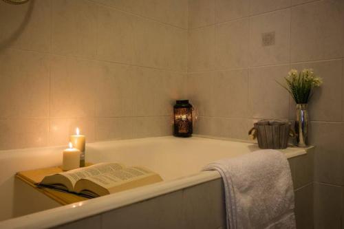 a bathroom with a bath tub with a book and candle at The Palm in Pognana Lario