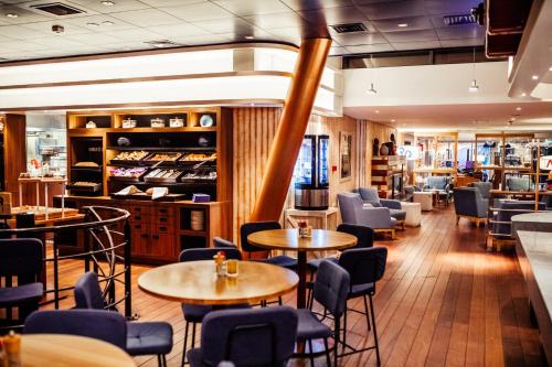 a restaurant with tables and chairs and a bar at Delta Hotel in Vlaardingen