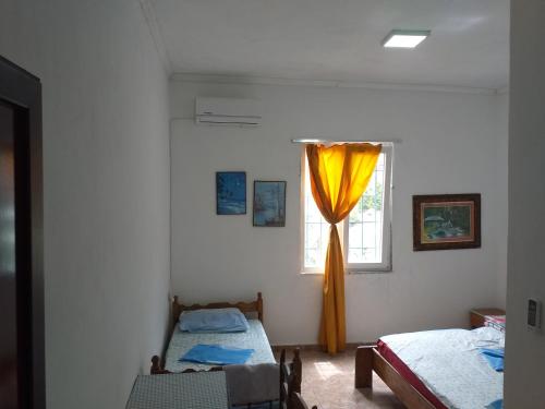 een slaapkamer met 2 bedden en een raam bij Rozafa Ferry & Accommodation in Koman