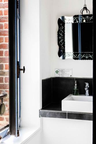 une salle de bain avec un lavabo et un miroir dans l'établissement La Femme d'à Côté, à Saint-Valery-sur-Somme