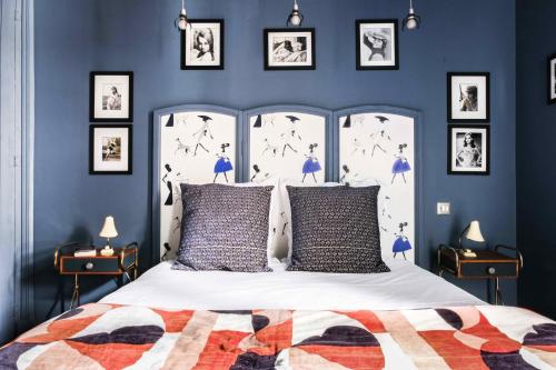 - une chambre avec des murs bleus et un lit blanc avec des oreillers dans l'établissement La Femme d'à Côté, à Saint-Valery-sur-Somme