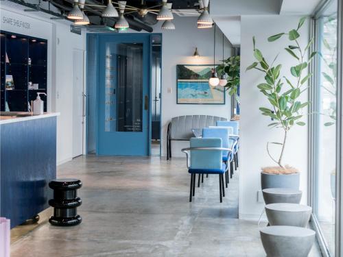 a dining room with blue chairs and a blue door at The Share Hotels Lyuro Tokyo Kiyosumi in Tokyo