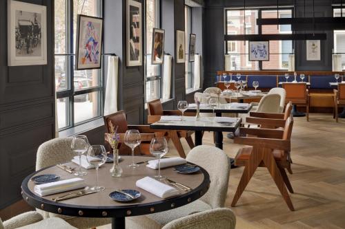 a restaurant with tables and chairs with wine glasses at Mövenpick Hotel The Hague in The Hague