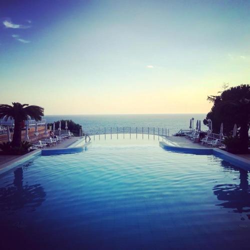 a large swimming pool with the ocean in the background at Hotel Club San Diego in Maratea