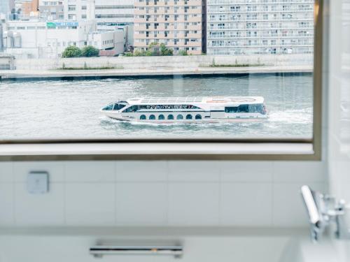 a boat on the water through a window at The Share Hotels Lyuro Tokyo Kiyosumi in Tokyo