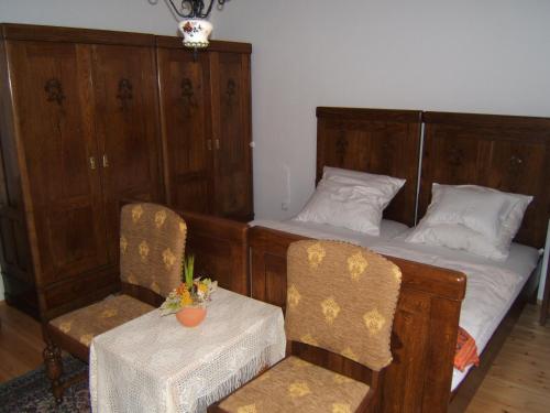 a bedroom with two beds and a table and chairs at Faluszéli Vendégház - Boncz Porta in Nagyrákos