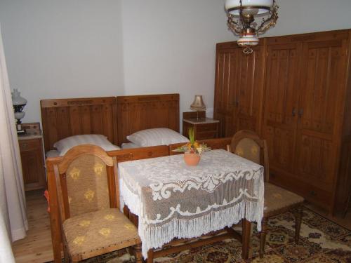 a room with two beds and a table and chairs at Faluszéli Vendégház - Boncz Porta in Nagyrákos