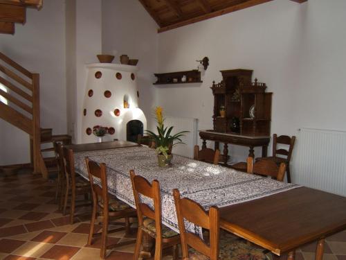 a dining room with a table and a piano at Faluszéli Vendégház - Boncz Porta in Nagyrákos