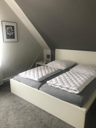 een slaapkamer met een wit bed met een wit frame bij Ferienwohnung Matti in Butjadingen