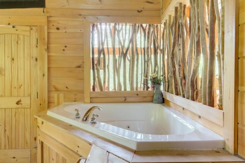 a large tub in a wooden bathroom with a window at Bear Necessities #71 in Sevierville