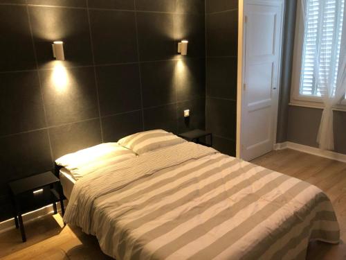 - une chambre avec un lit et deux lumières sur le mur dans l'établissement Monfs Apparts Clermont-Ferrand, pres de toute commodites, à Clermont-Ferrand