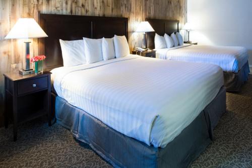 two beds in a hotel room with two lamps at Mission Inn in Santa Cruz