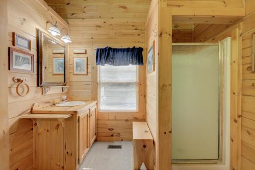a log cabin bathroom with a sink and a shower at Whispering Pines #33 in Sevierville