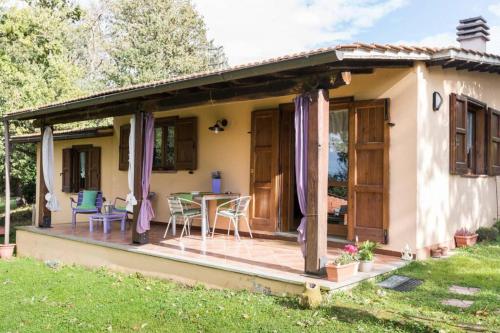 een huisje met een terras met een tafel en stoelen bij B&B Agriturismo La Casetta di Ben in Viterbo