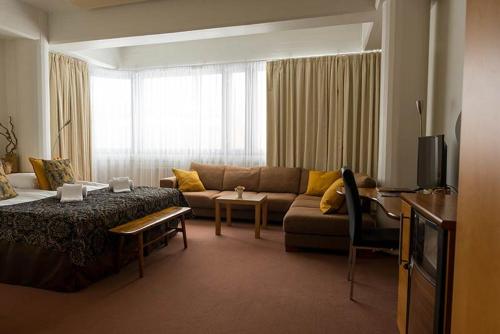 sala de estar con sofá, mesa y TV en Hotelliravintola Kumpu, en Outokumpu