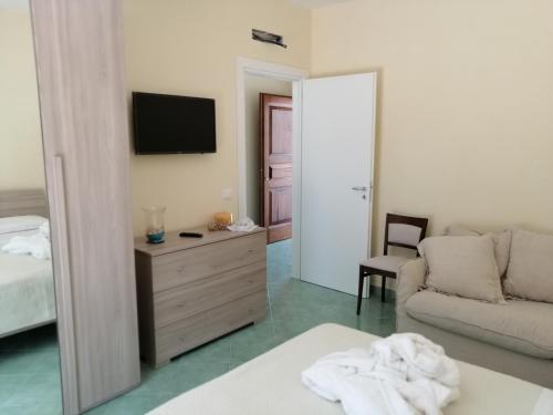 Hotel Terme Alexander في ايسكيا: غرفة معيشة مع سرير وأريكة