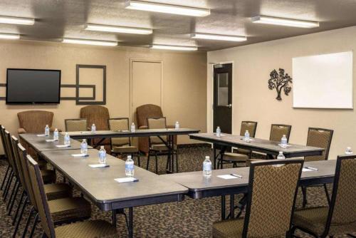 a conference room with tables and chairs and a screen at Travelodge by Wyndham Wellington in Wellington