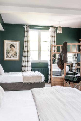 - une chambre avec 2 lits superposés et un mur vert dans l'établissement Au Velocipede, à Saint-Valery-sur-Somme