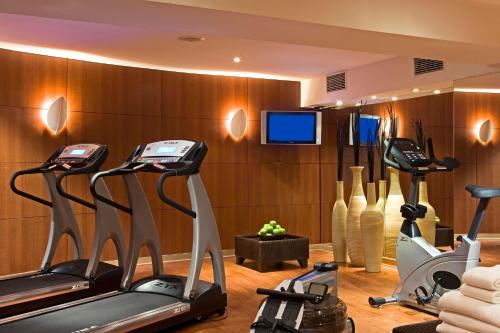 a gym with several exercise bikes and a tv at Warwick Grand-Place Brussels in Brussels