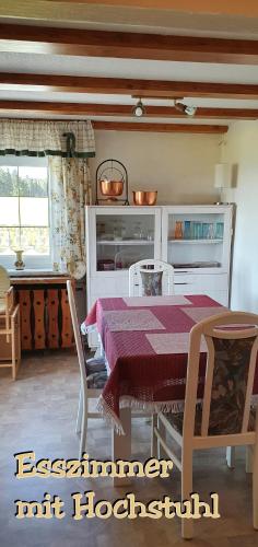 a dining room with a table and chairs and a kitchen at Landhaus "Kühler Morgen", Komfortable 65 qm FeWo mit gehobener Ausstattung, Garten, baby- und kindgerecht in Saalburg-Ebersdorf