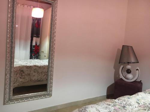 a mirror in a bedroom with a bed and a lamp at Villa Masullo in Mercogliano