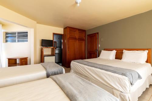 a hotel room with two beds and a television at Canzi Cataratas Hotel in Foz do Iguaçu