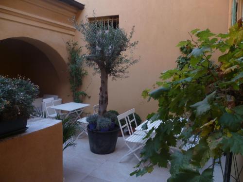 a patio with a table and chairs and a tree at Hotel Rossetti in Nice